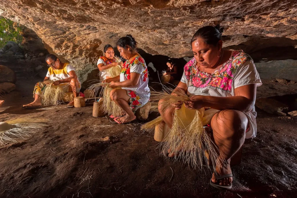 mujeres en cueva elaborando sombreros